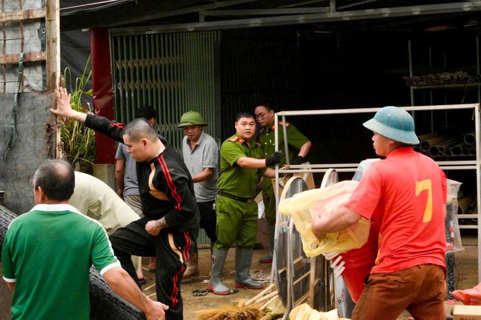 Người dân và lực lượng tại chỗ hỗ trợ các hộ gia đình di dời tài sản đến nơi an toàn. Ảnh: Nguyễn Hoàn